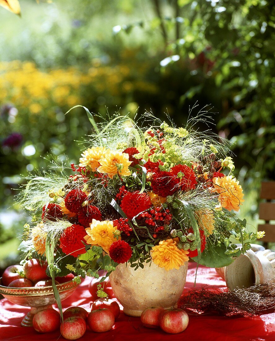 Autumn table decoration with bouquet of dahlias & small apples
