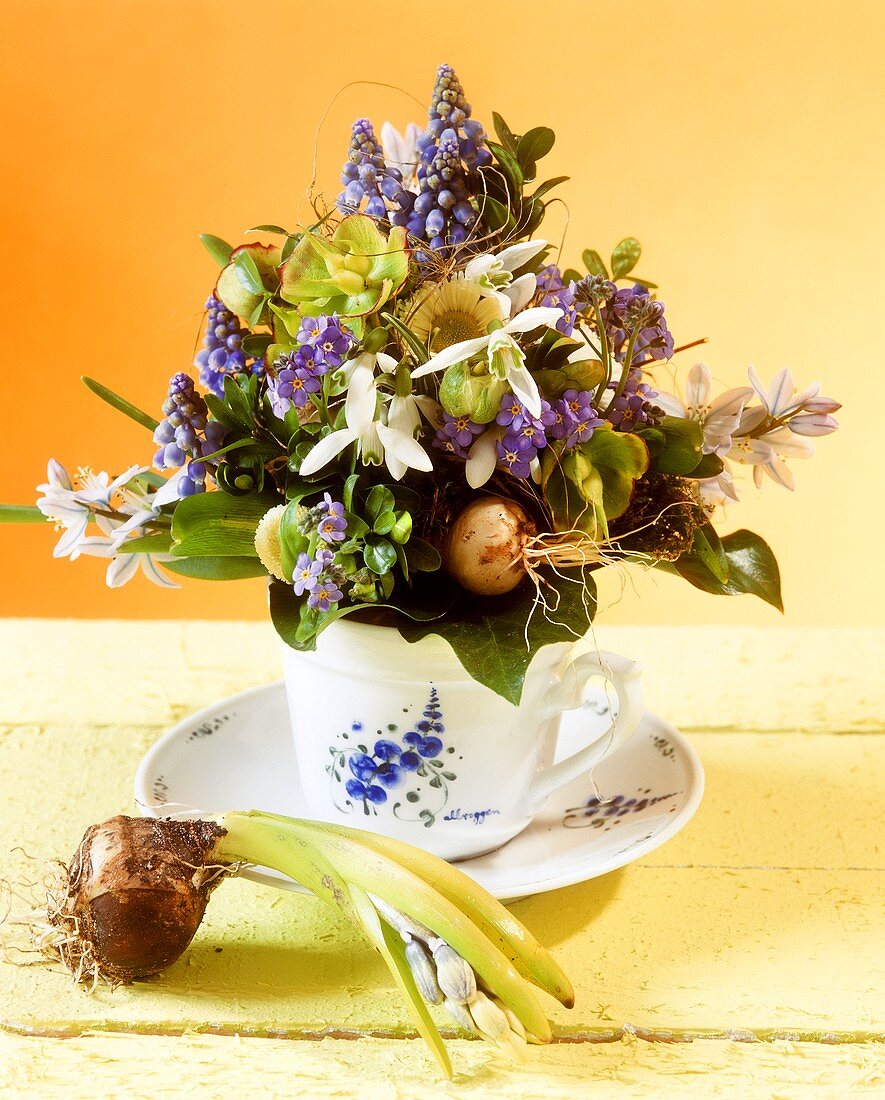 Phantasievoll dekorierte Kaffeetasse mit Frühlingsblumen