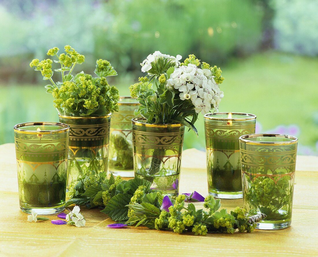 Teegläser, dekoriert mit Gartenblumen und Kerzen