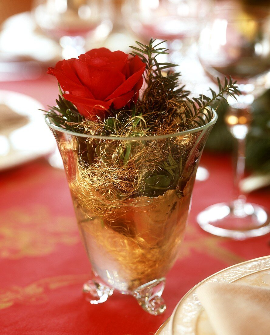 Weihnachtlich dekoriertes Glas mit Rose, Tanne & Engelshaar
