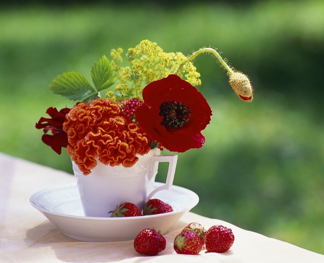 Tischdeko mit verschiedenen Blüten in einer Kaffeetasse