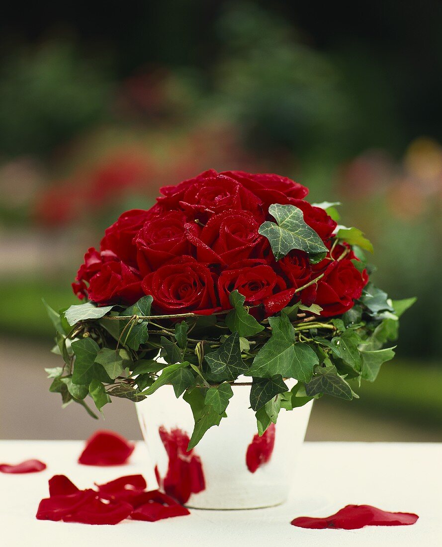 Gesteck aus roten Rosen und Efeuranken