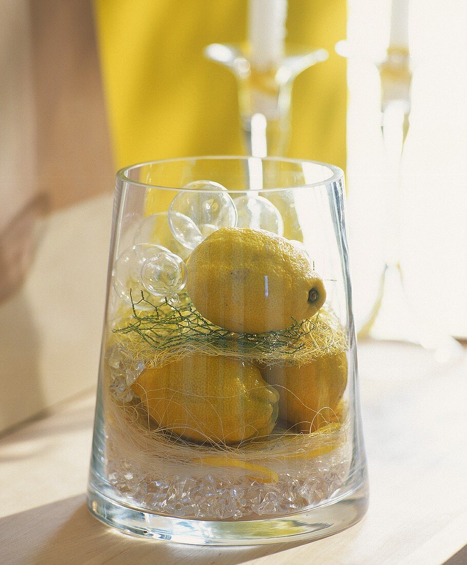 Table decoration of lemons in glass container