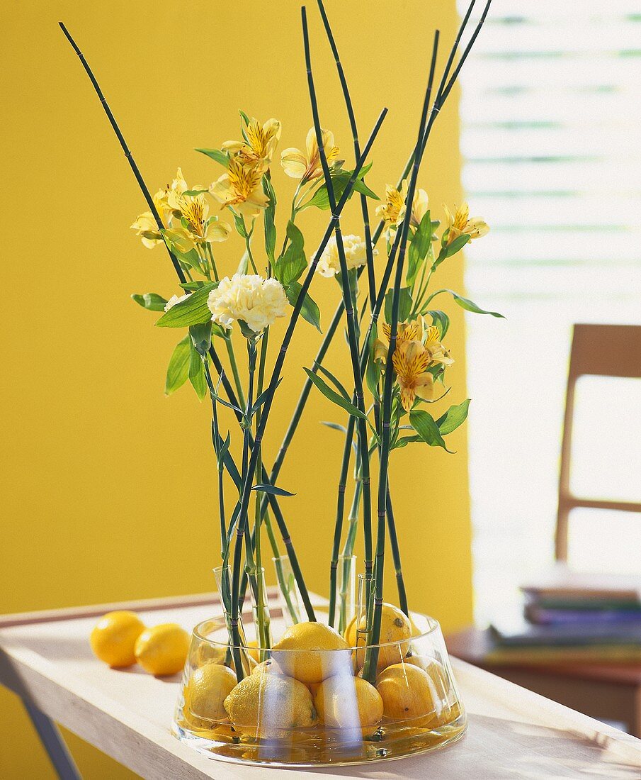Blumenarrangement mit Zitronen, Inkalilien und gelben Nelken