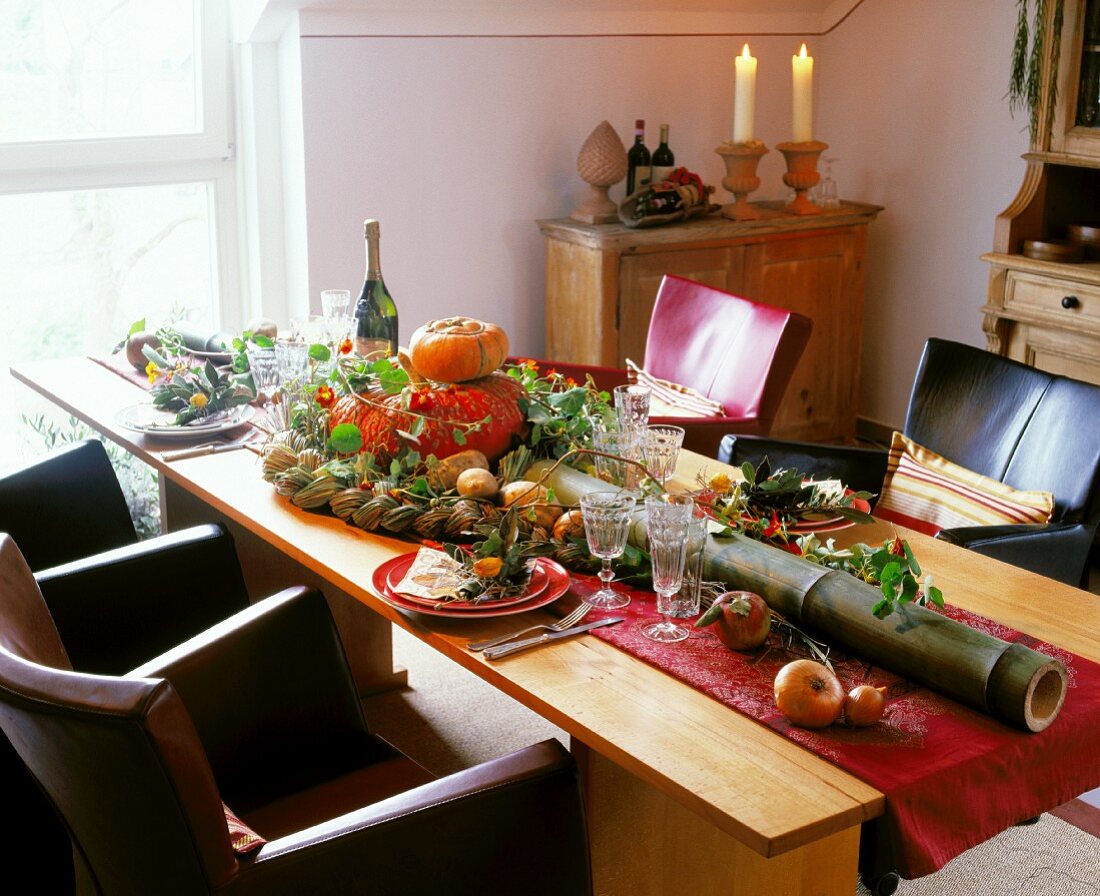 Autumnal dining table decorated with pumpkin and a long bamboo stem