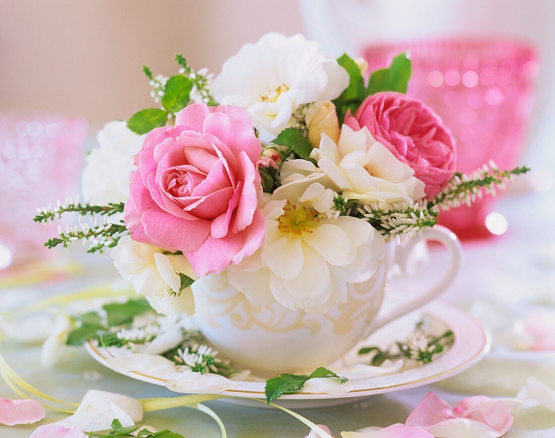White and pink roses and heather in a cup