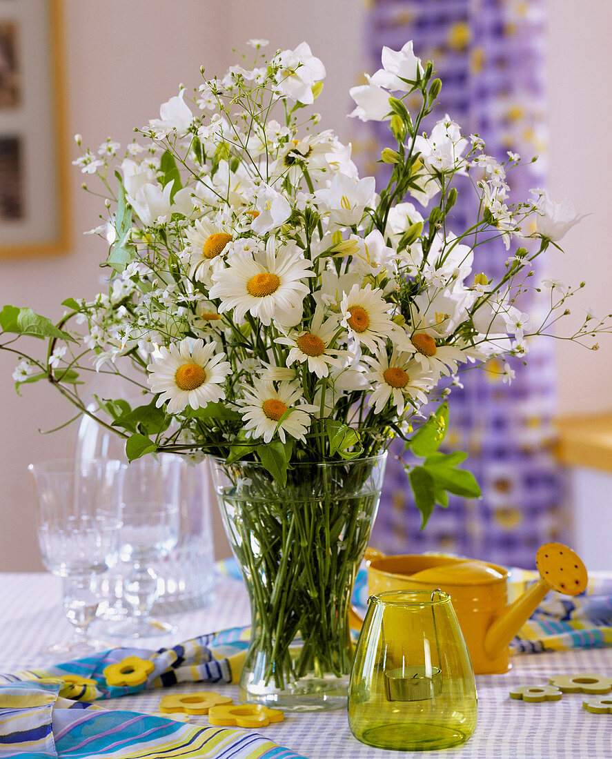 Weißer Strauß aus Sommer-Margerite, Glockenblume und Schleierkraut in einer Glasvase