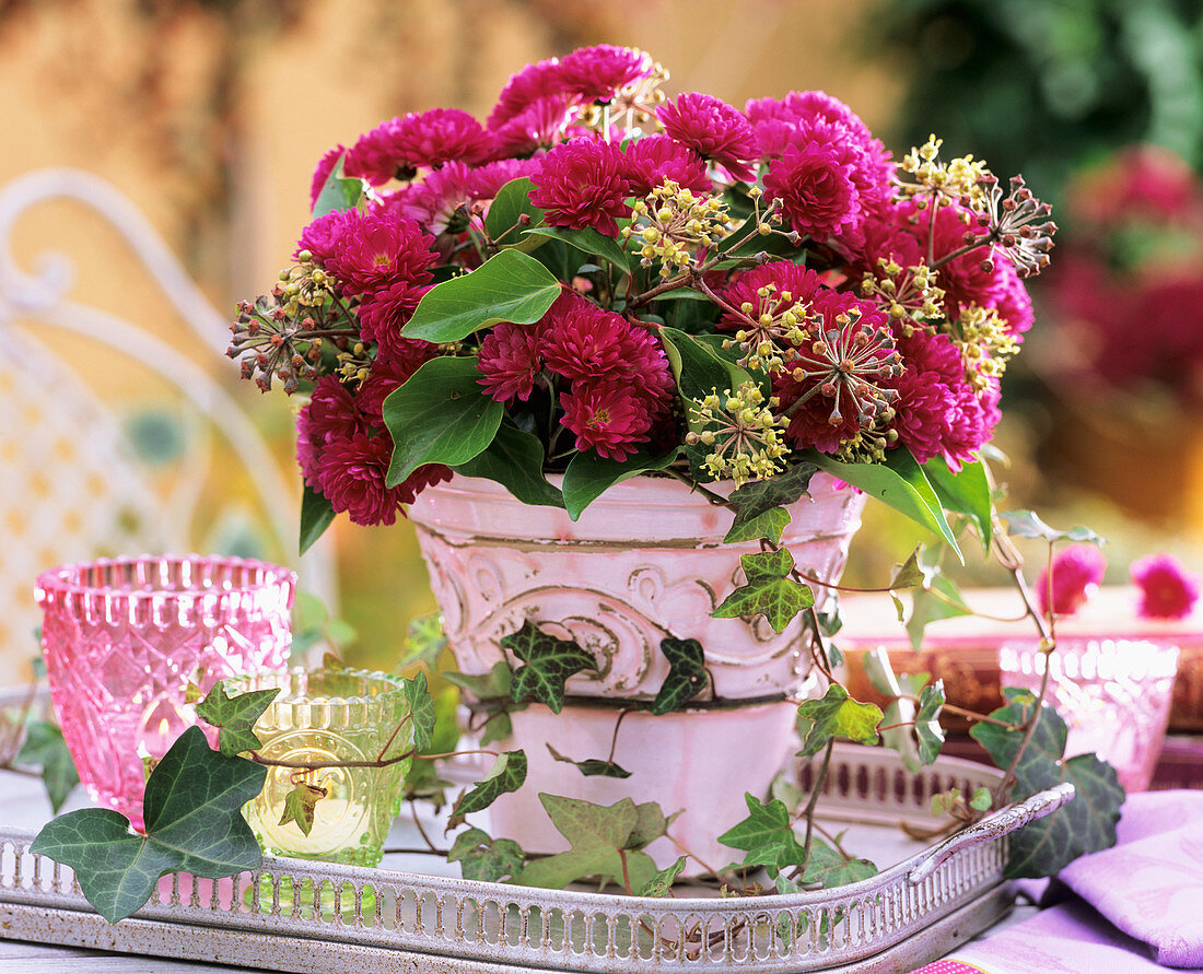 Chrysanthemums, ivy and seed heads in pink pot