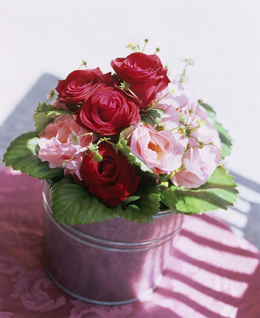 Bouquet of double and single roses and strawberry flowers