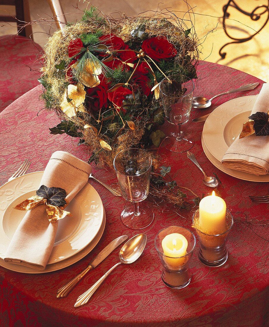 Christmas arrangement of roses, two place-settings beside it