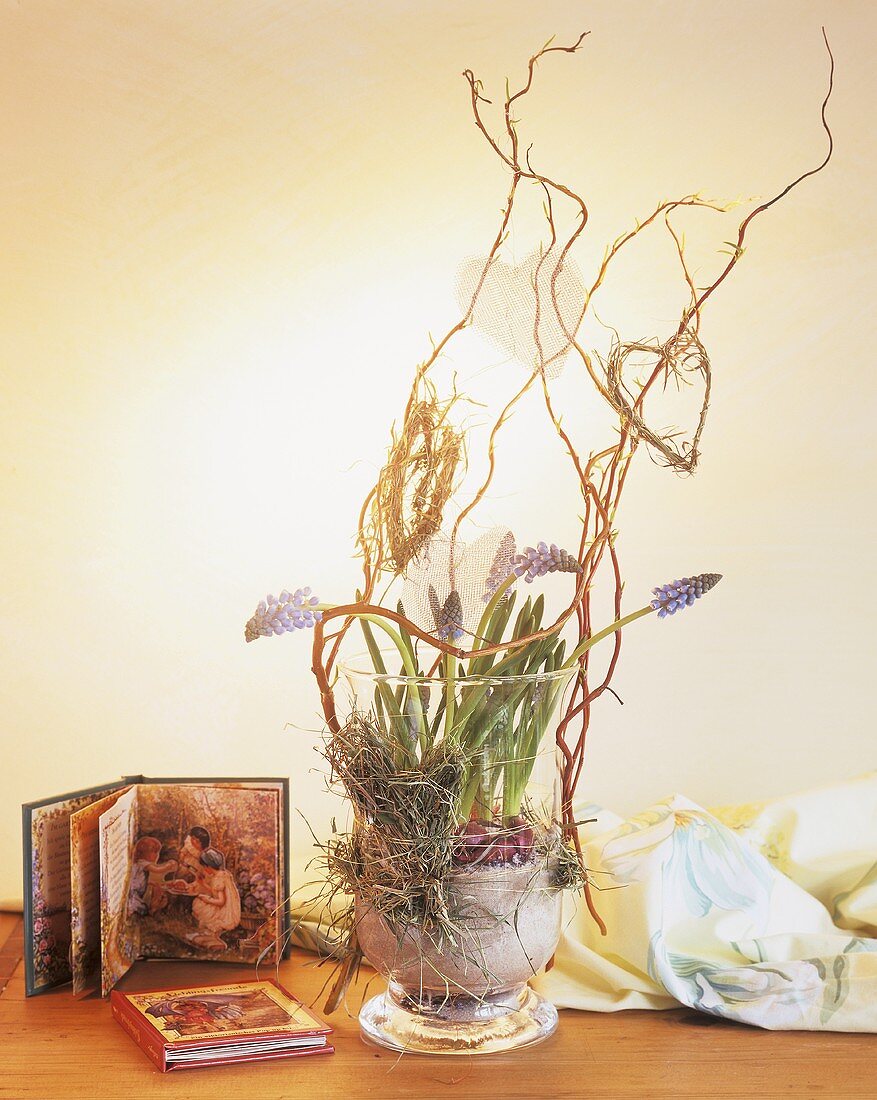 Glass of grape hyacinths with twigs and hearts