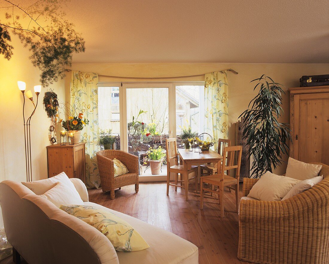 Gemütliches Landhauszimmer mit Zimmerpflanzen zwischen Holz- & Korbmöbeln
