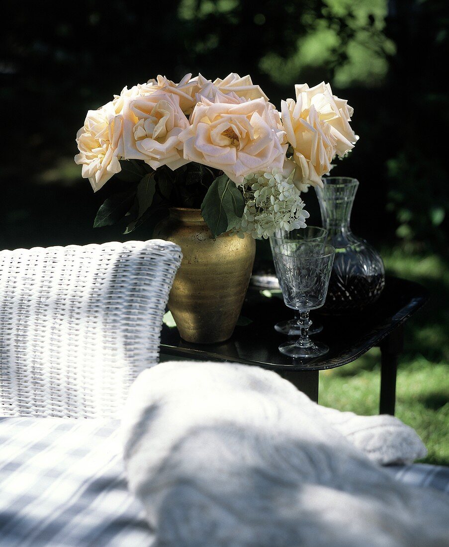 Rosenstrauss in Vase am Beistelltisch im Garten