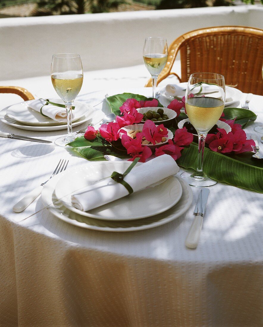 Laid table with tapas on banana leaves and flowers
