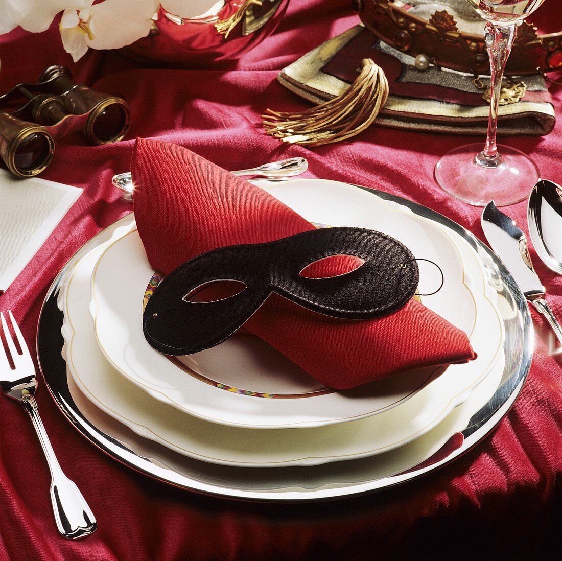 Festliches Gedeck mit roter Serviette & schwarzer Maske