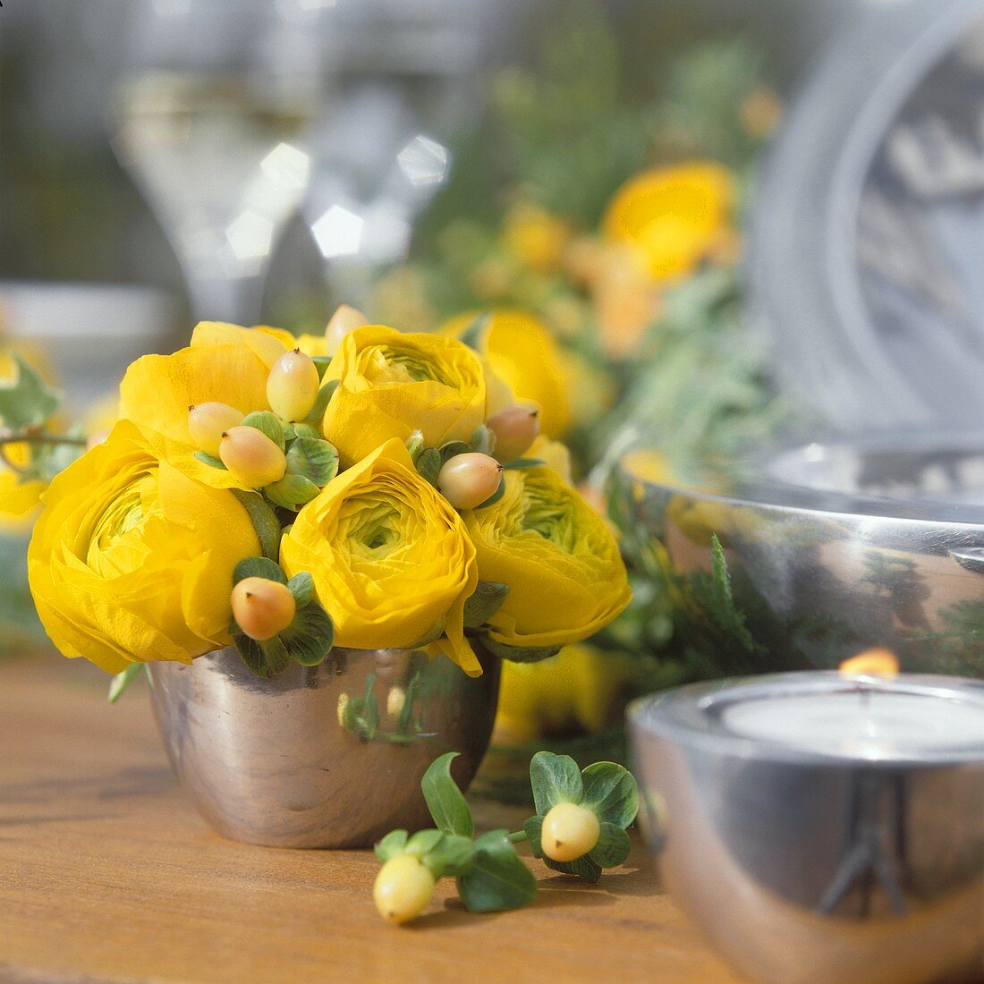 Gelbe Blumen in Silbervase als Tischdeko