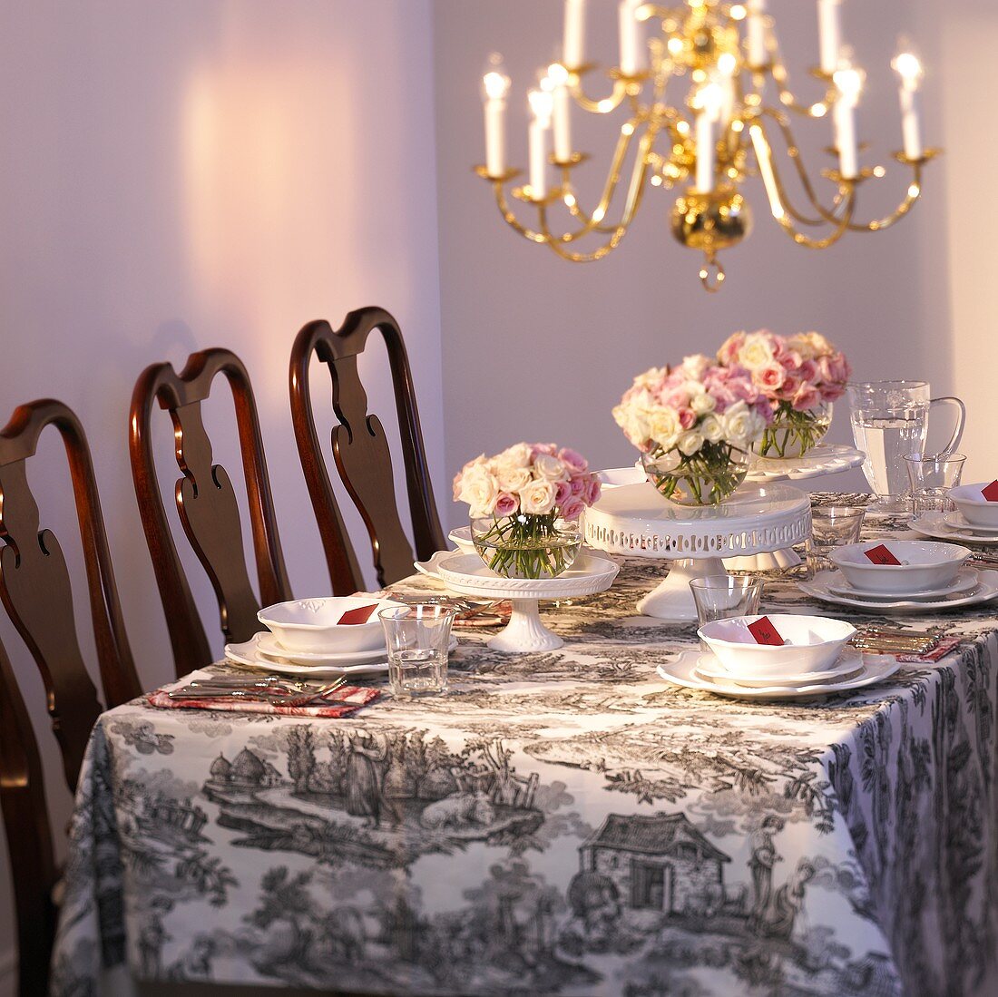 Festlich gedeckter Tisch mit weißem Geschirr und Rosen
