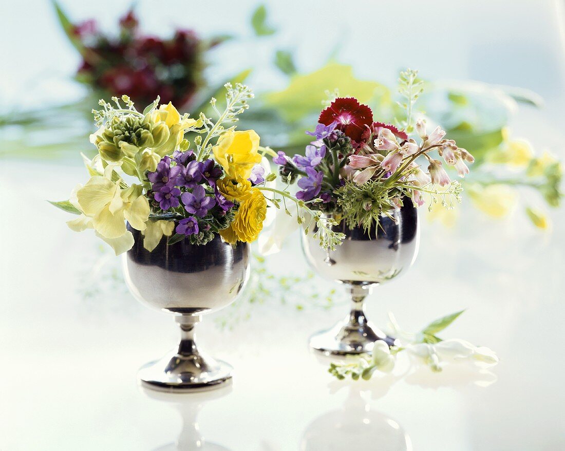 Small posies of flowers in silver goblets