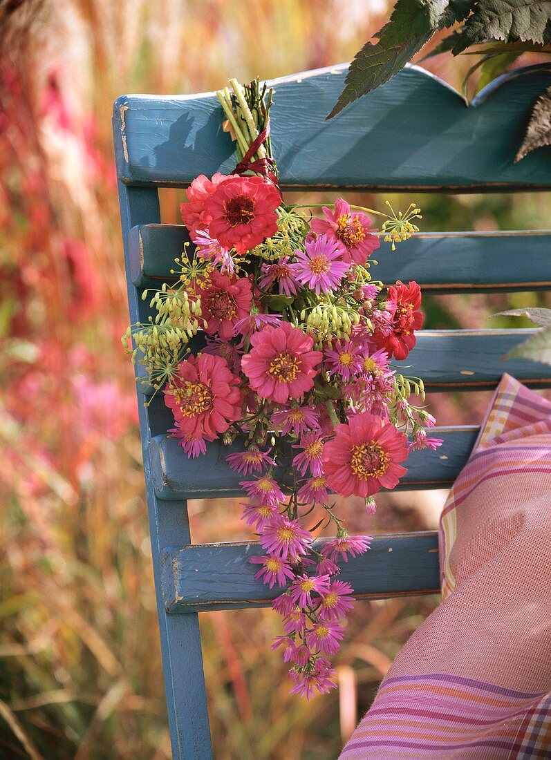 Small bunch of zinnias and asters on chair back