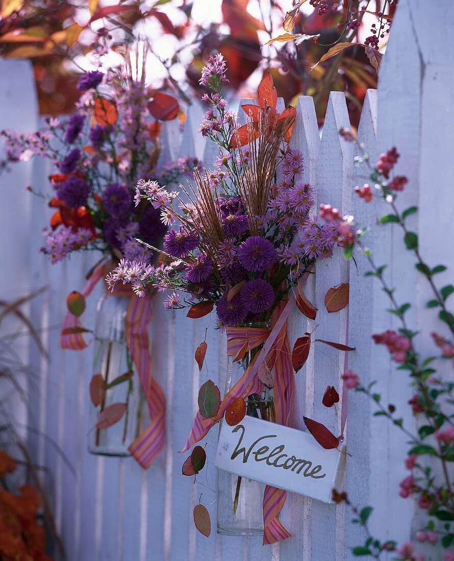 Herbstliche Blumendeko am Gartenzaun mit Schild Welcome