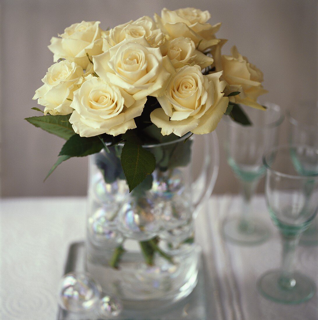 White roses in a glass jug