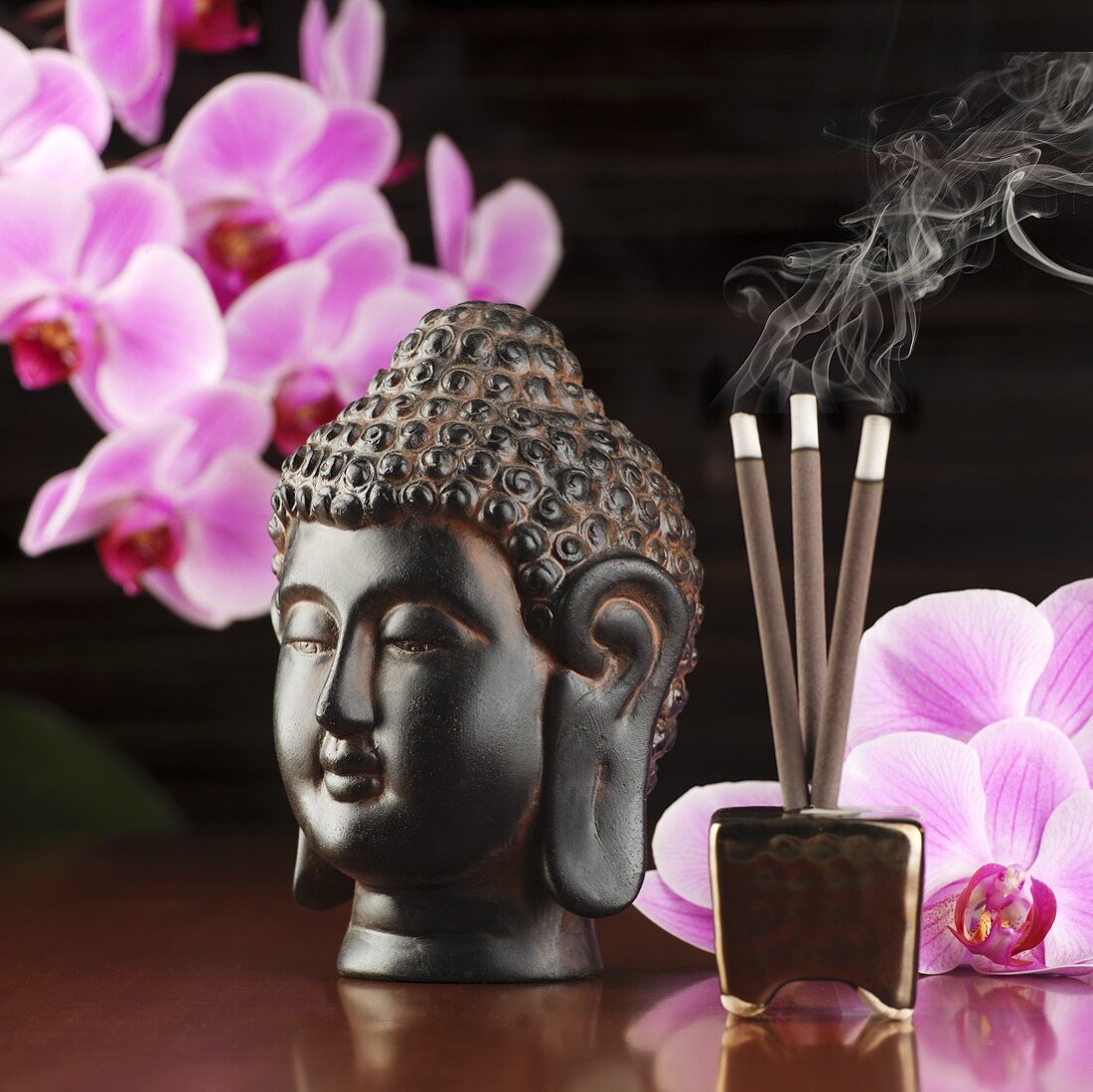 Buddhakopf, Orchideen und Räucherstäbchen