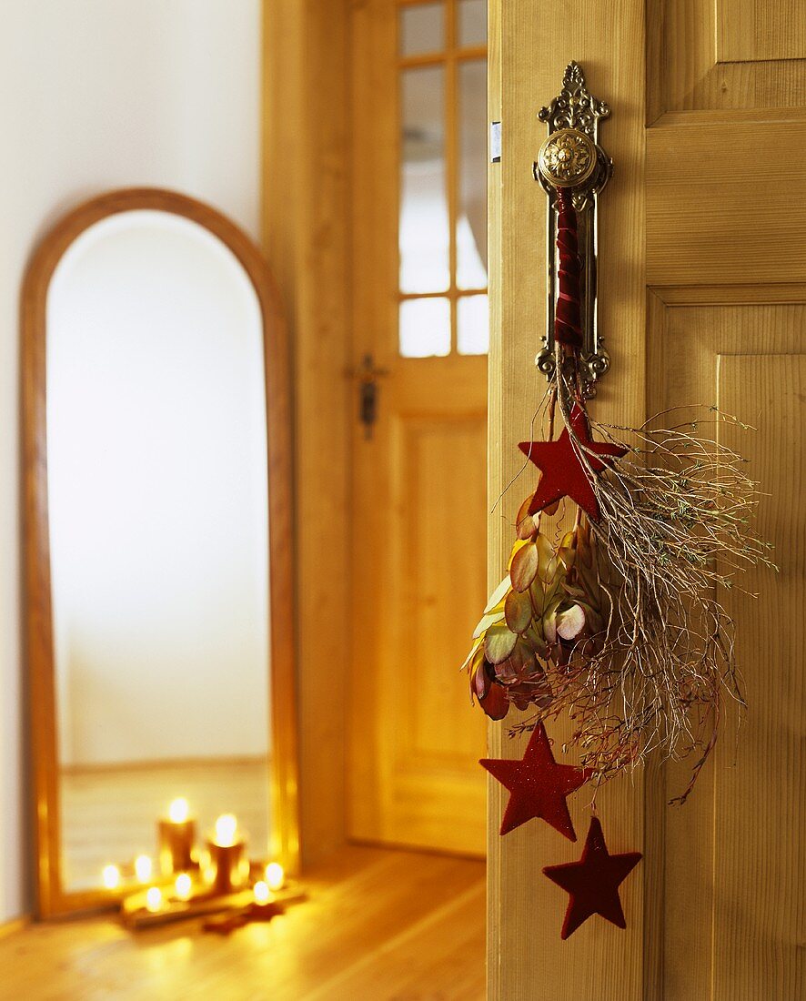 Door handle decorated with felt stars and Euphorbia twigs