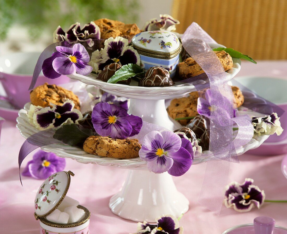 Tiered stand with biscuits, chocolates and pansies