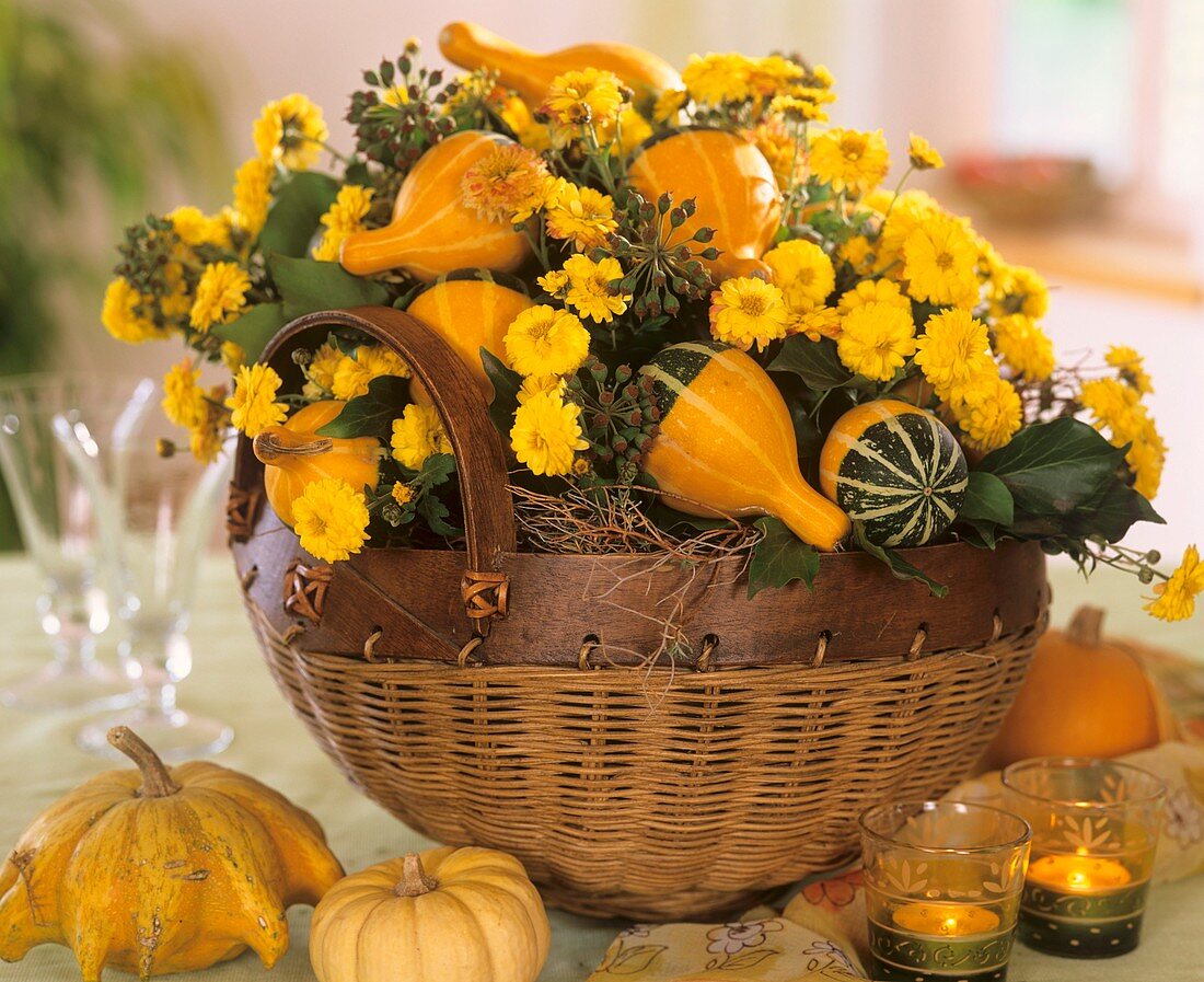 Korb mit Gesteck aus Chrysanthemen und Zierkürbissen