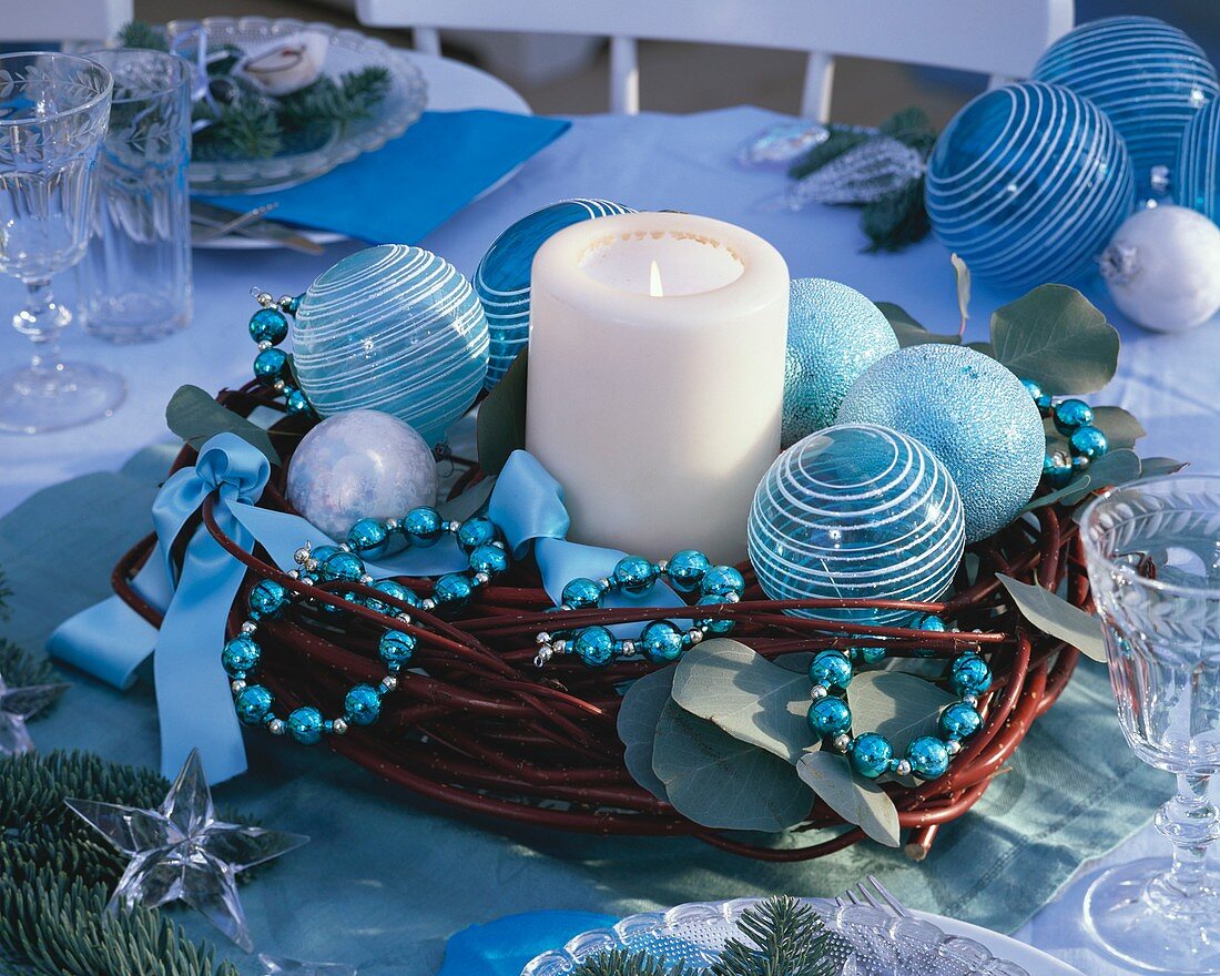 Kerze umgeben von Hartriegel-Kranz mit blauem Baumschmuck