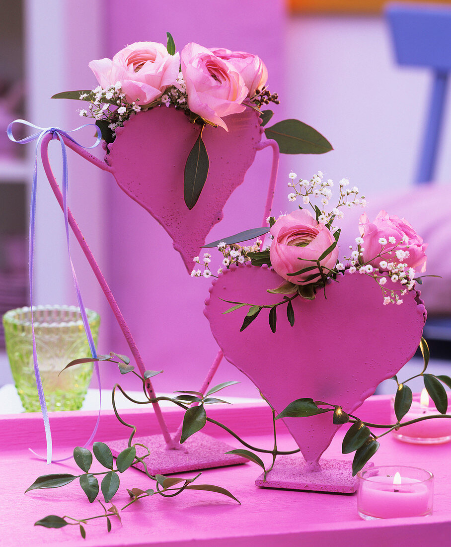 Ranunkeln, Schleierkraut und Jasminranke in rosa Blumenvasen