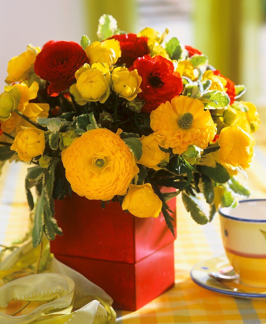 Arrangement of Ranunculus, globe flowers and peppermint