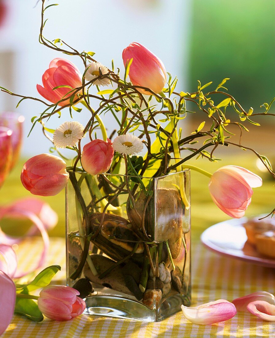 Modernes Gesteck aus Tulpen, Tausendschön und Korkenzieherweide in Glasvase