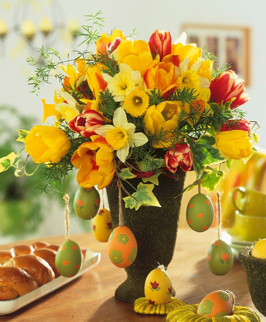 Strauss aus Tulpen, Narzissen und Ostereiern, daneben Osterzopf