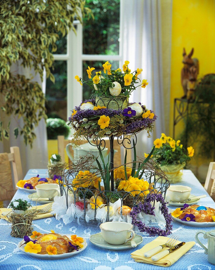 Österlich gedeckter Tisch mit Blumenetagere und Hefekranz