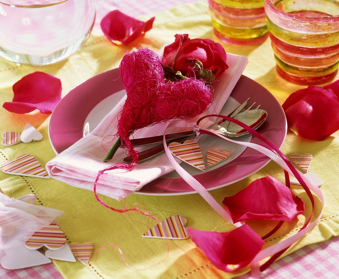 Place-setting with red sisal heart and rose 
