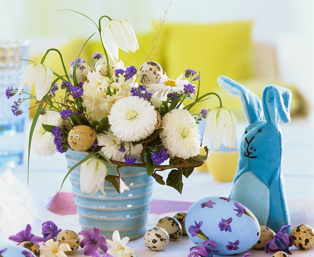 Easter arrangement with quail's eggs and felt hat as egg cosy