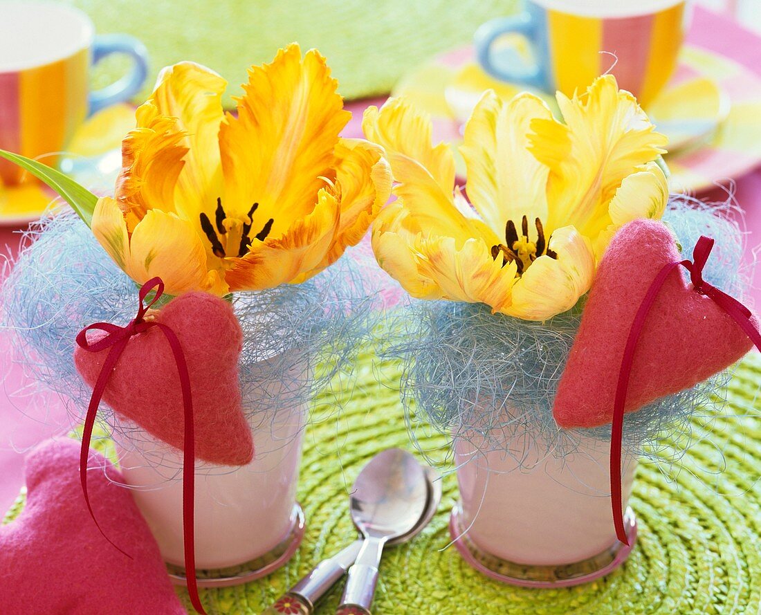 Gelbe Tulpen mit blauem Sisal und rosa Filzherzen