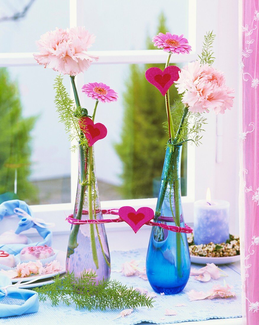 Carnations, Gerbera & ornamental asparagus in glass vases