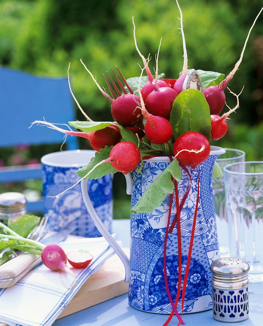 Bunch of radishes in blue and white jug