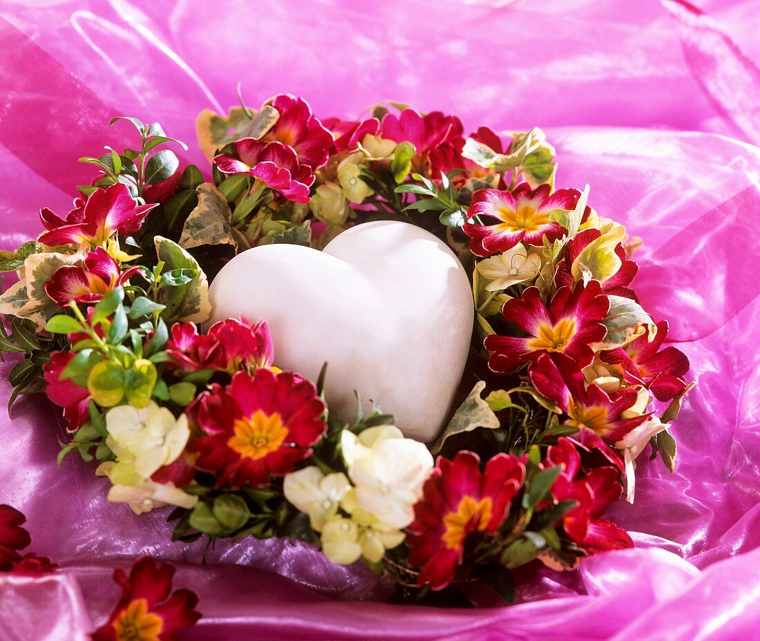 Heart in a wreath of primulas and hydrangea flowers