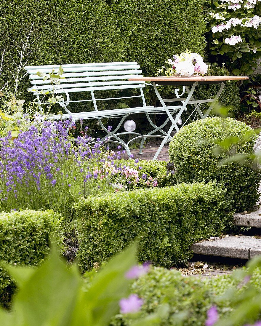 Garden seat and table in summery garden