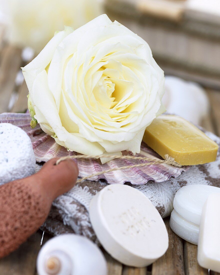 White rose and perfumed soaps on towel