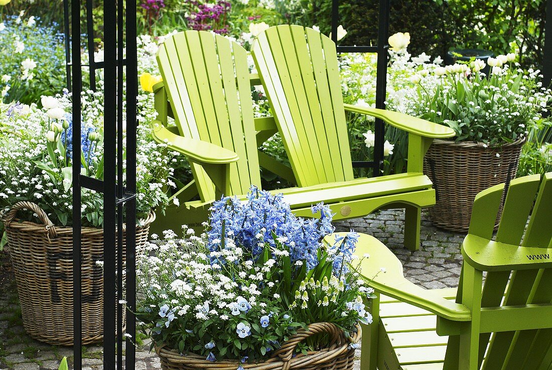 Garden furniture among baskets of spring flowers