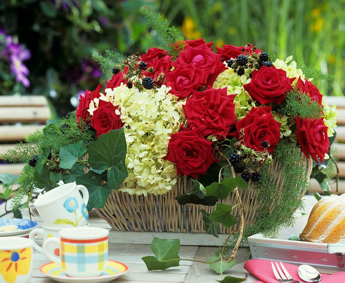 Basket of red roses, hydrangeas and blackberries