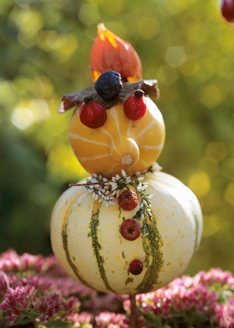 Little man made from ornamental gourds, rose hips, heather
