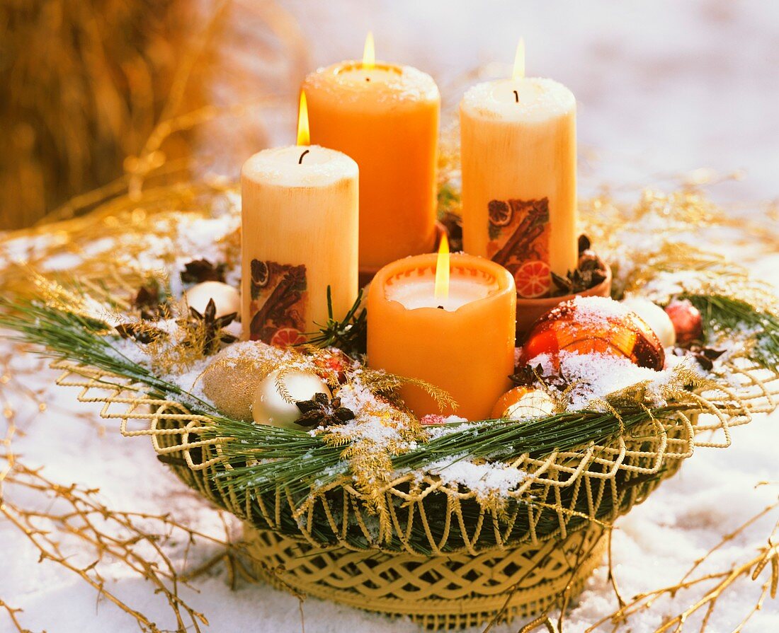Adventlich dekorierter Drahtkorb mit vier Kerzen