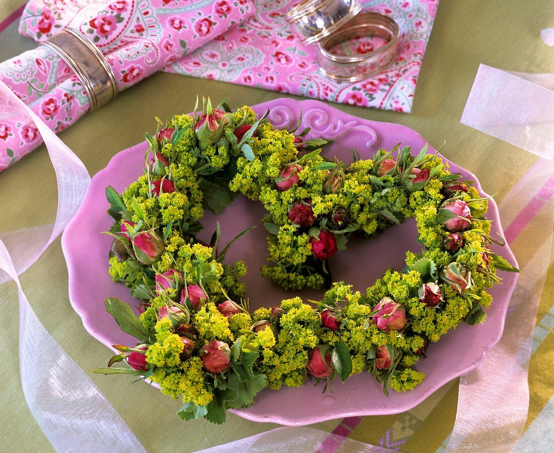Herzförmiges Blumengesteck aus Rosen und Frauenmantel