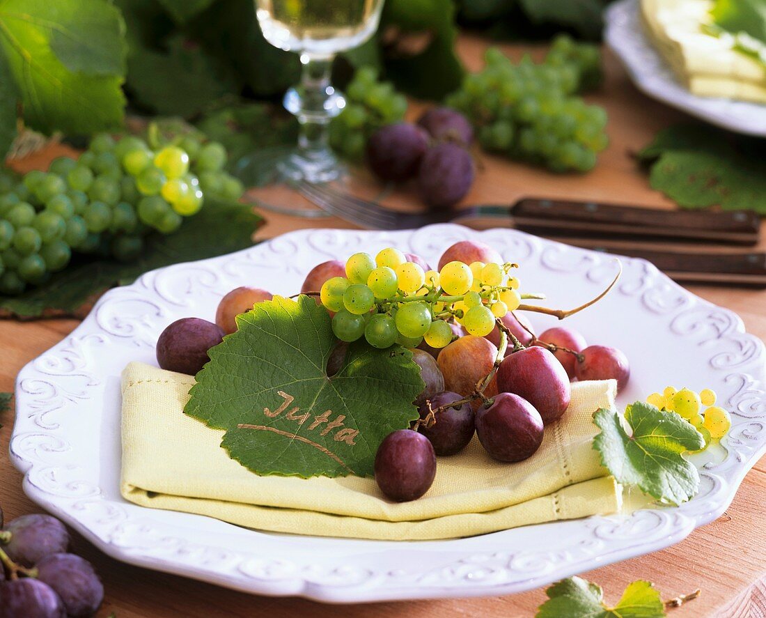 Weintrauben und Weinblatt als Platzkarte auf Serviette