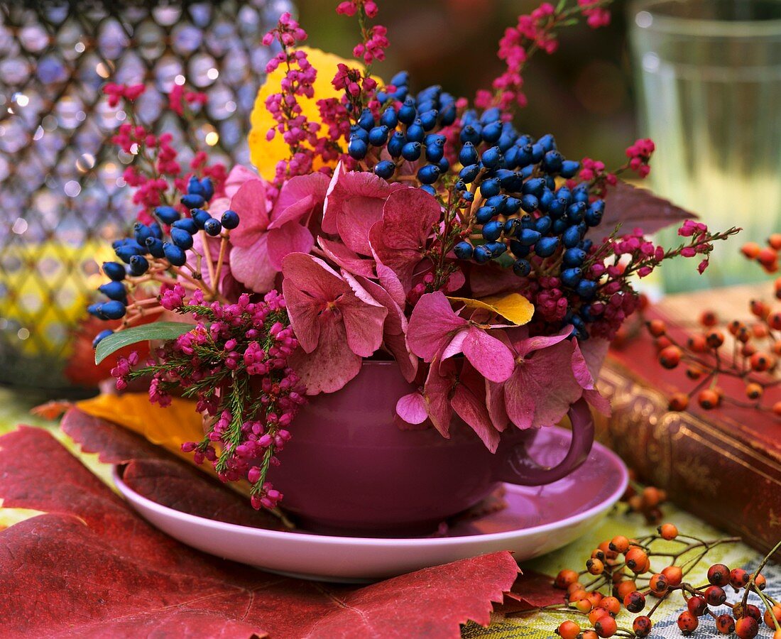Herbstliches Blumengesteck mit Beeren schmückt einen Tisch